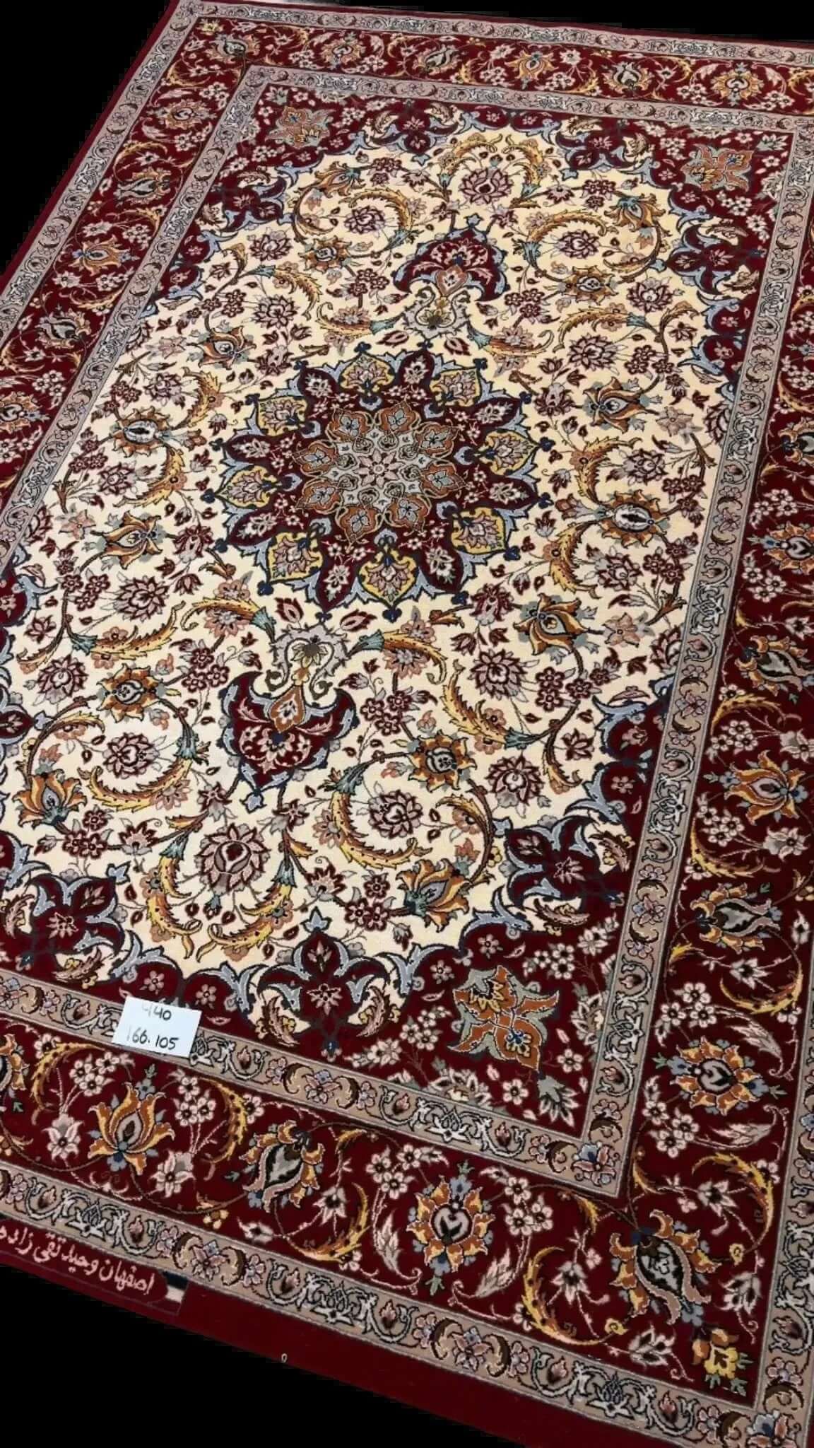 "Elegant wool and silk Persian rug from Isfahan, hand-knotted by master weaver Taghiezadeh. This luxurious 166 cm x 105 cm rug adds timeless beauty to any space."